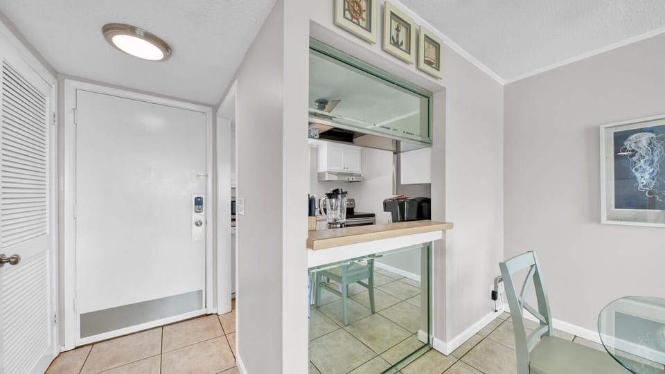 The bright, white kitchen is fully equipped and features a pass-through breakfast bar.