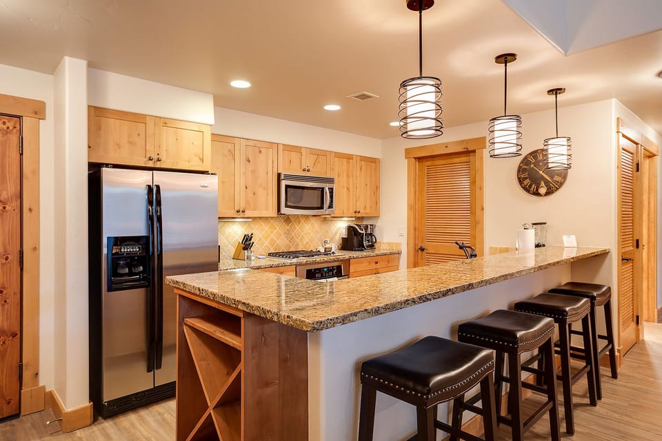 Your fully equipped kitchen features granite counters, stainless appliances, and a breakfast bar where you can enjoy morning coffee together.