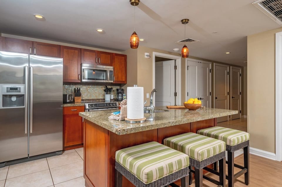 Your kitchen features granite counters, full-size stainless appliances, and bar seating for three, ideal for casual breakfasts before heading out to the beach.