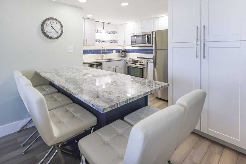This modern kitchen features sleek cabinetry, stainless appliances, and a spacious granite island perfect for gathering
