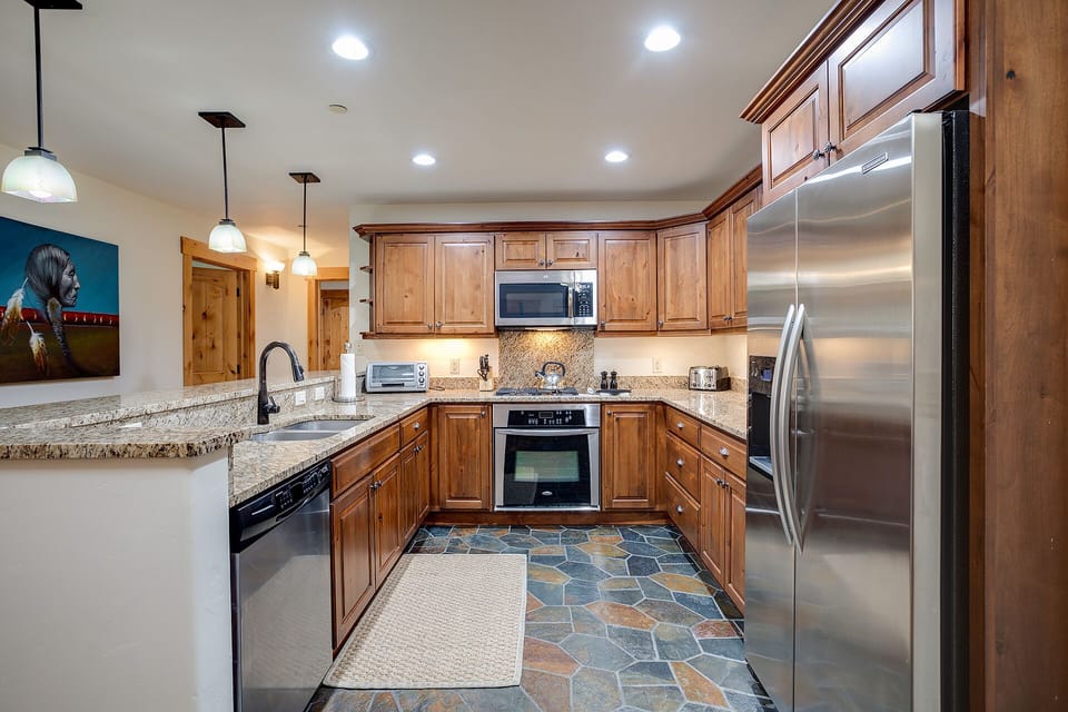 You'll love cooking in this spacious kitchen featuring warm wood cabinets, granite countertops, and stainless steel appliances.