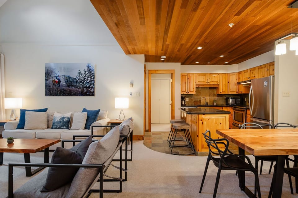 Open plan living/dining/kitchen with warm tones and vaulted ceilings, plus a wood-burning fireplace to complete the tranquil setting.