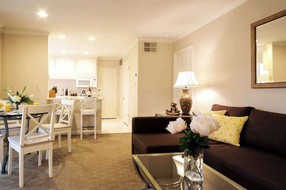 Unwind in our charming living room, featuring open kitchen access and comfy bar stools. Perfect for conversation & connection over home-cooked meals. 