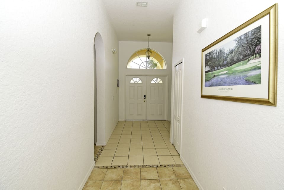 Entry hallway with tiled flooring and front door.