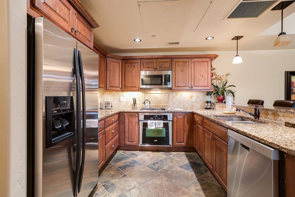 Your fully equipped kitchen features granite counters, stainless appliances, and warm wood cabinets for memorable home-cooked meals.