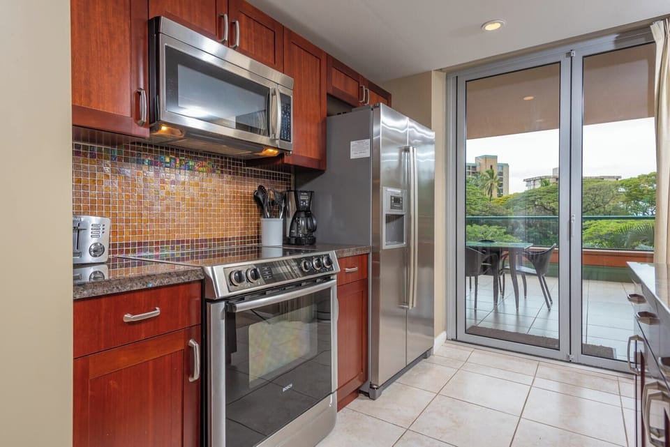 Sleek kitchen with mosaic backsplash and access to outdoor dining