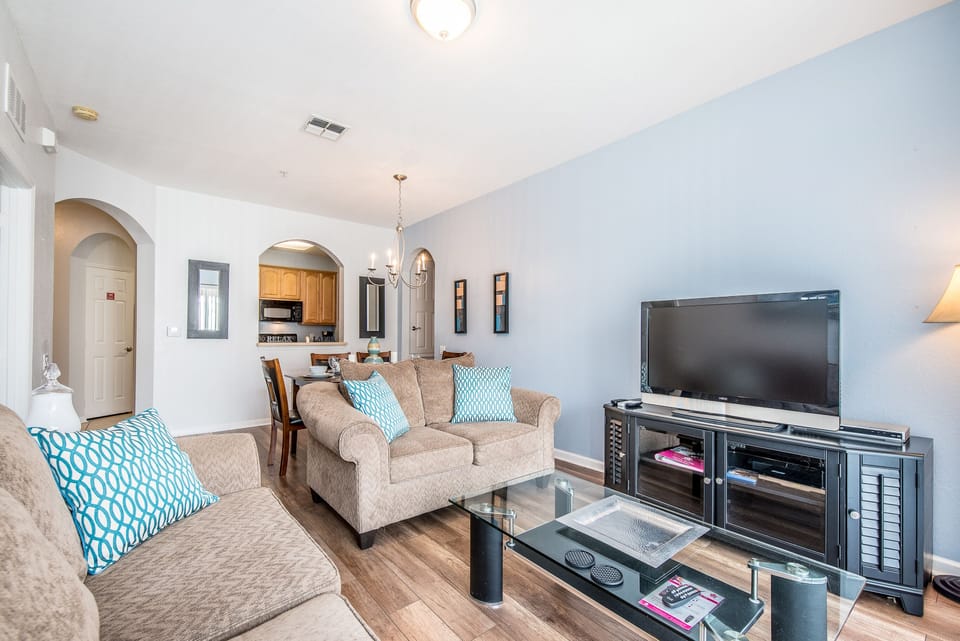 The simple yet inviting living area sits conveniently beside the dining table and kitchen, providing easy access to the private balcony for a seamless indoor-outdoor living experience.