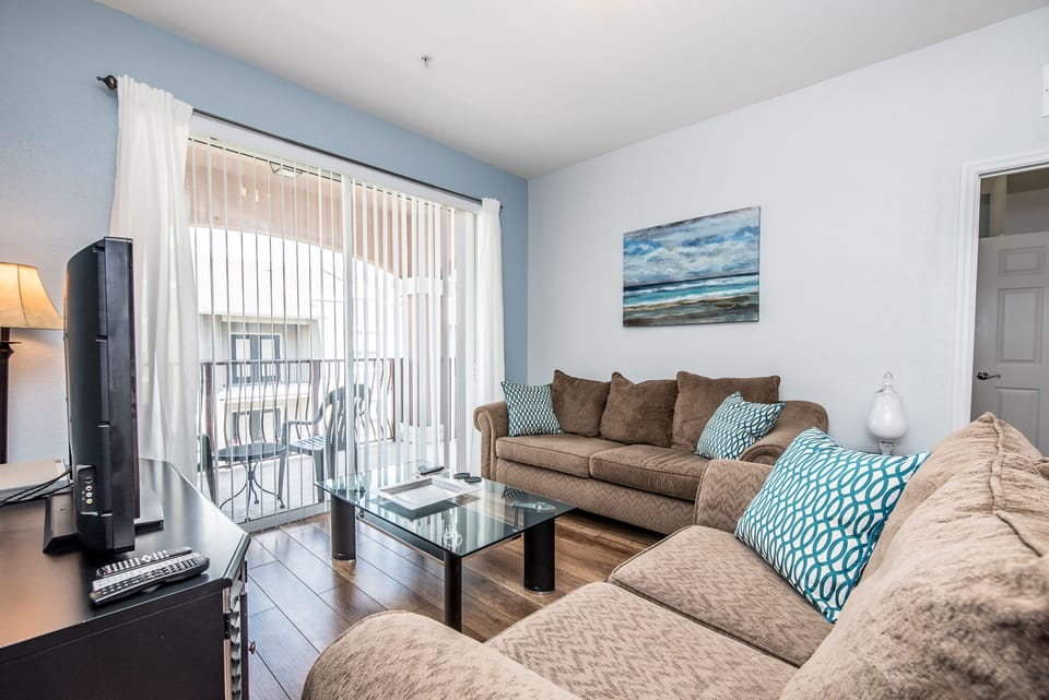 This simple yet functional living area is conveniently situated next to the dining table and kitchen, offering easy access to the private balcony for seamless indoor-outdoor living.