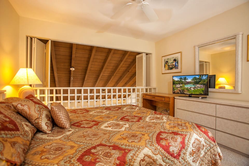 Curl up in your cozy bedroom with warm wood ceilings, soft lighting, and tropical views on the TV—perfect for unwinding after a sun-filled day.