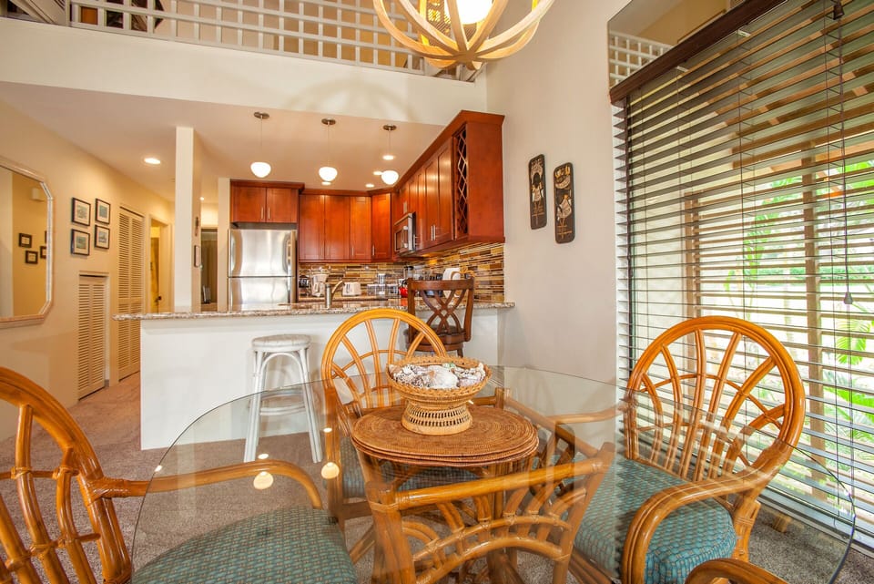 A bright, open-concept space with a charming glass dining table and a fully equipped kitchen ready for your culinary adventures and shared meals.