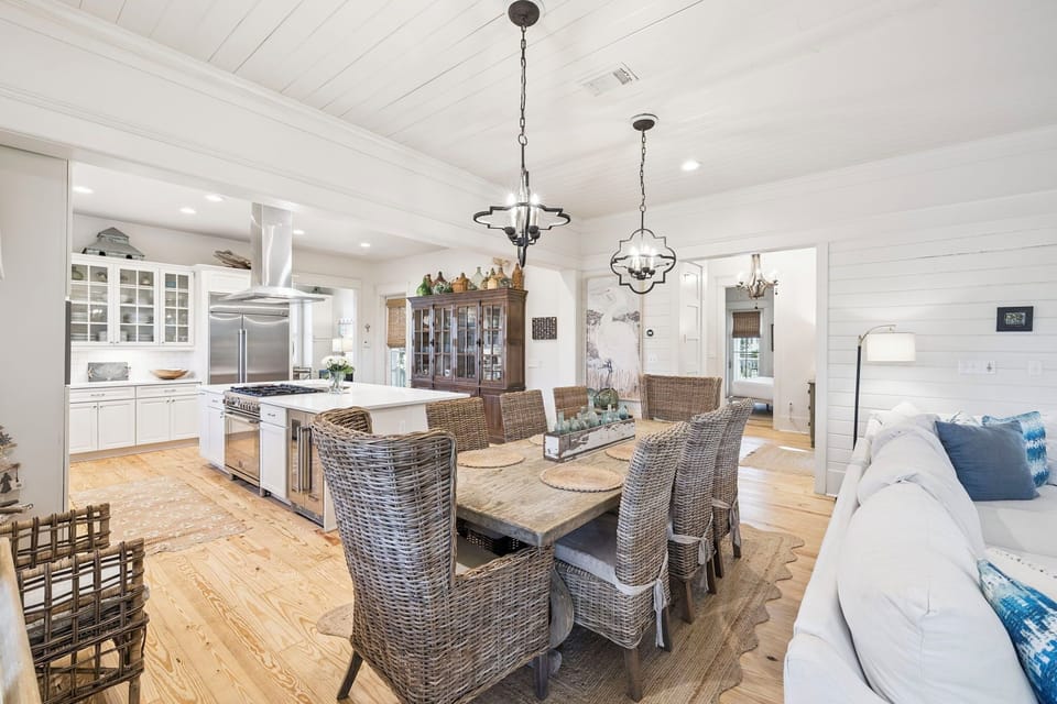 Gather around this stunning open-concept kitchen and dining space where coastal elegance meets farmhouse charm for memorable meals.