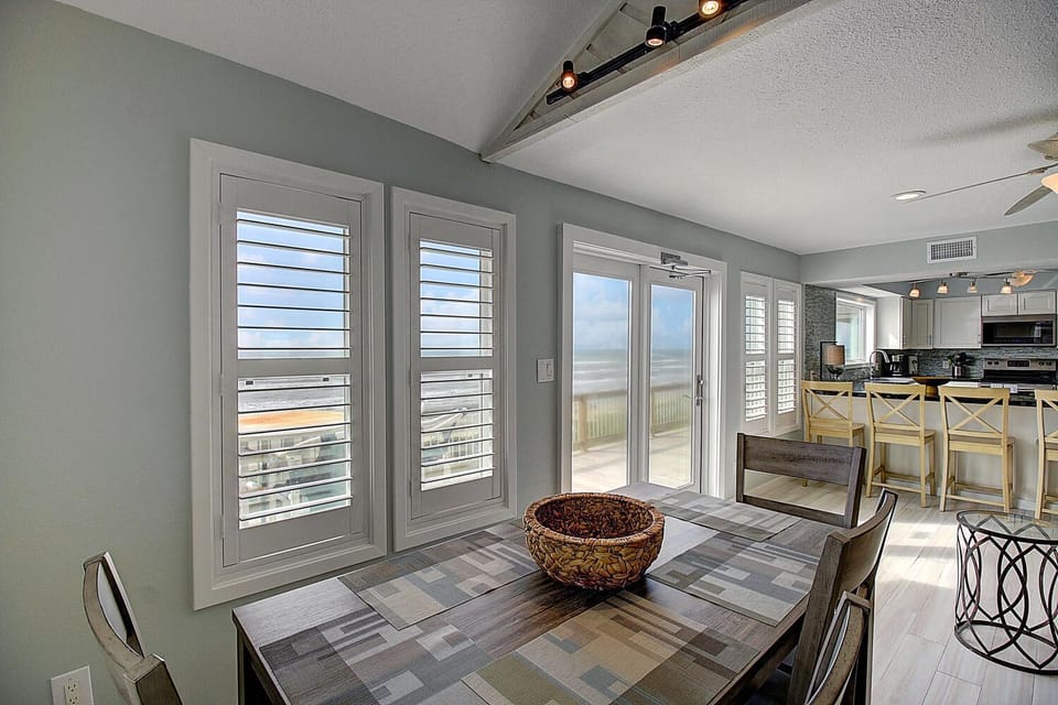 Your oceanfront dining room offers sweeping beach views through elegant shutters, creating perfect moments for meals with loved ones.