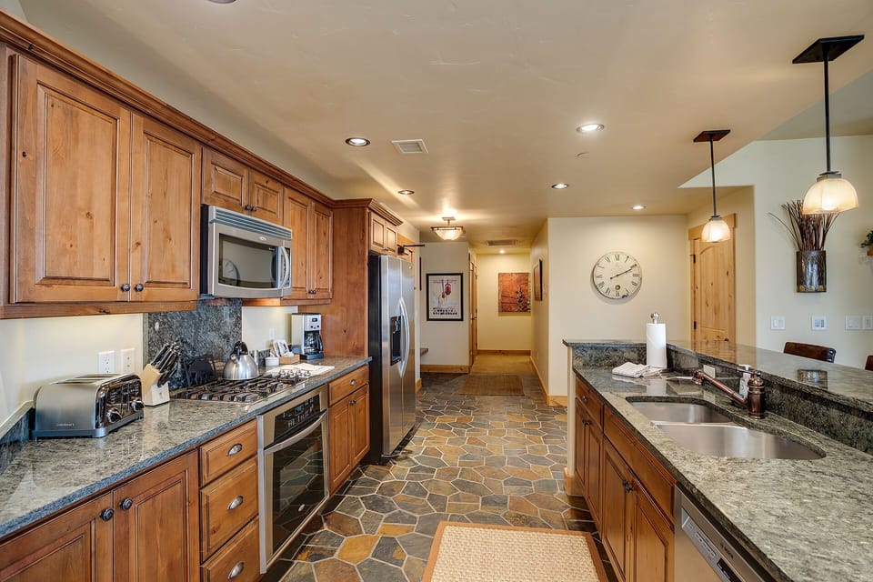 Your fully equipped kitchen features granite countertops, warm wood cabinets, and stainless steel appliances—perfect for preparing meals during your stay.