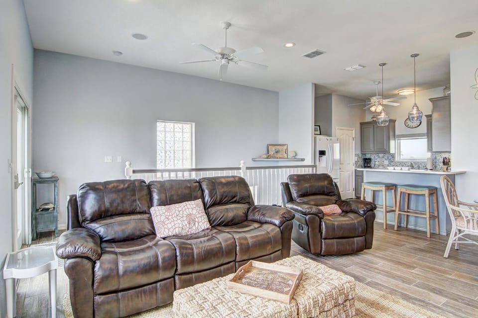 Sink into plush leather recliners in your open-concept living space, where modern comfort meets thoughtful design and natural light fills the room.