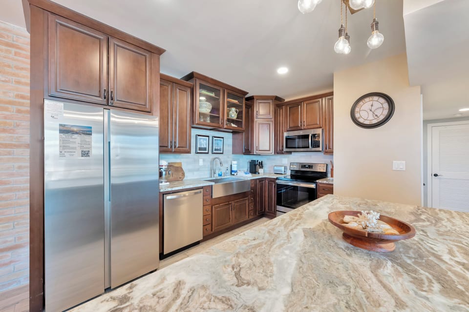 Your fully equipped kitchen features gleaming granite countertops, rich wood cabinetry, and stainless steel appliances—perfect for preparing memorable meals during your stay.