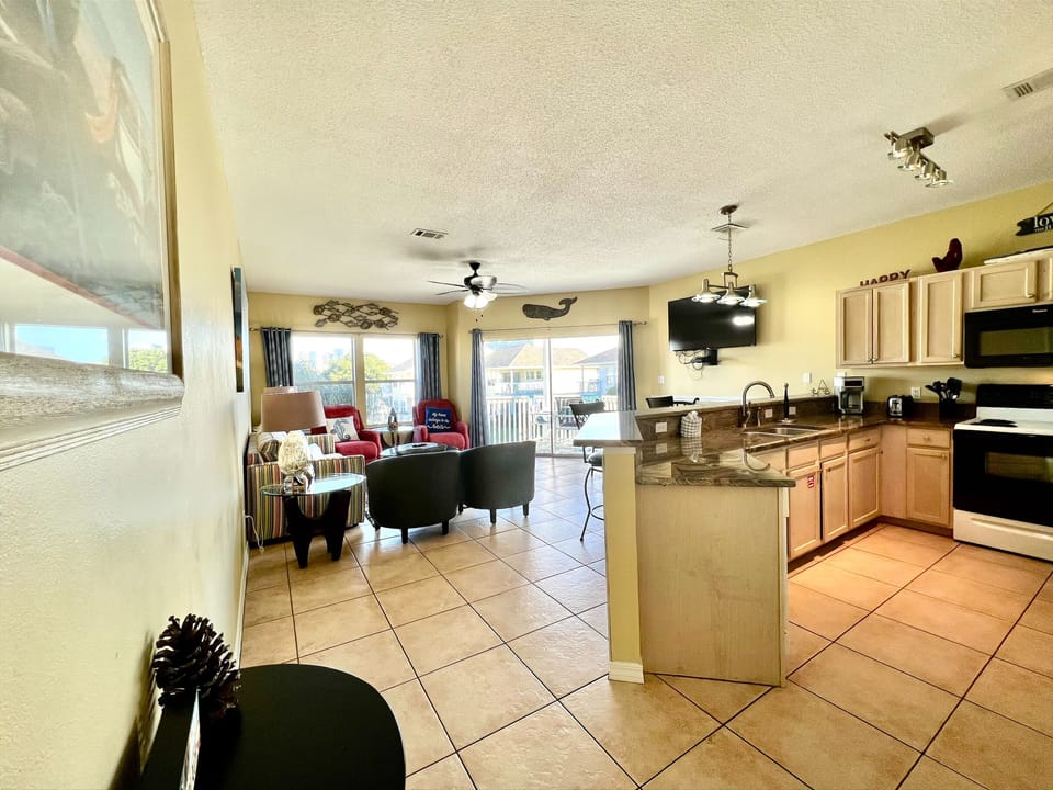 Your open kitchen flows seamlessly into the living area, perfect for gathering while meals are prepared. Natural light fills the space through sliding doors to your private balcony.