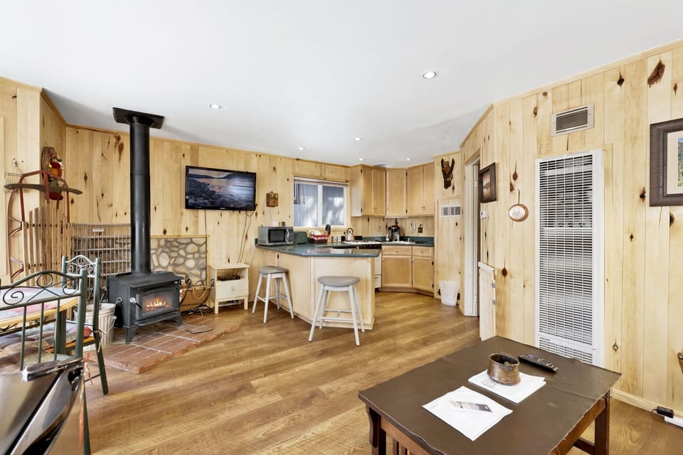 Cozy mountain living room with a stone, comfy seating, and smart TV—perfect for relaxing evenings, movie nights, and warm cabin vibes after outdoor adventures.