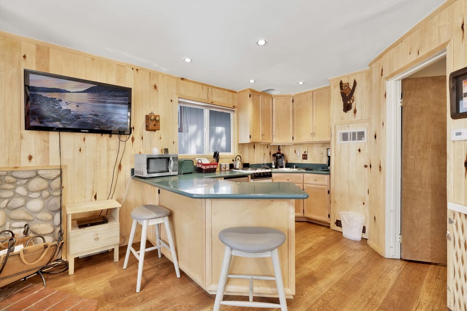 Fully equipped cabin kitchen with ample cabinetry, stove, fridge, microwave, and coffee maker—perfect for cooking meals, morning coffee, and feeling right at home on your stay.