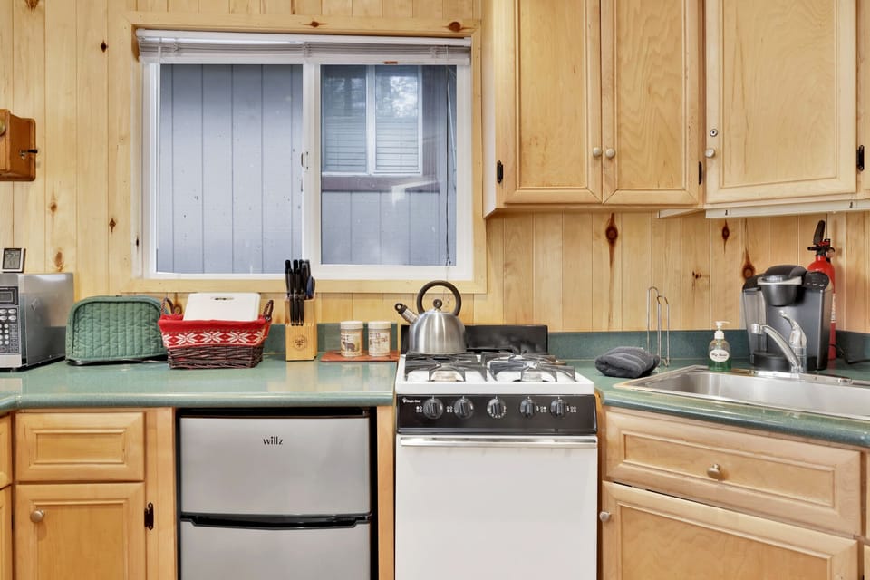 Fully equipped cabin kitchen with ample cabinetry, stove, fridge, microwave, and coffee maker—perfect for cooking meals, morning coffee, and feeling right at home on your stay.