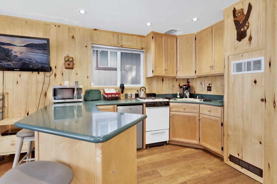 Fully equipped cabin kitchen with ample cabinetry, stove, fridge, microwave, and coffee maker—perfect for cooking meals, morning coffee, and feeling right at home on your stay.