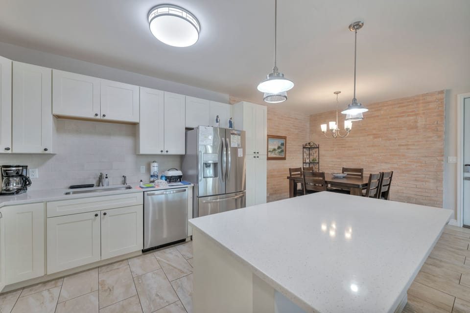 You'll love preparing meals in this bright, modern kitchen with gleaming countertops, stainless steel appliances, and a welcoming dining area perfect for gathering.