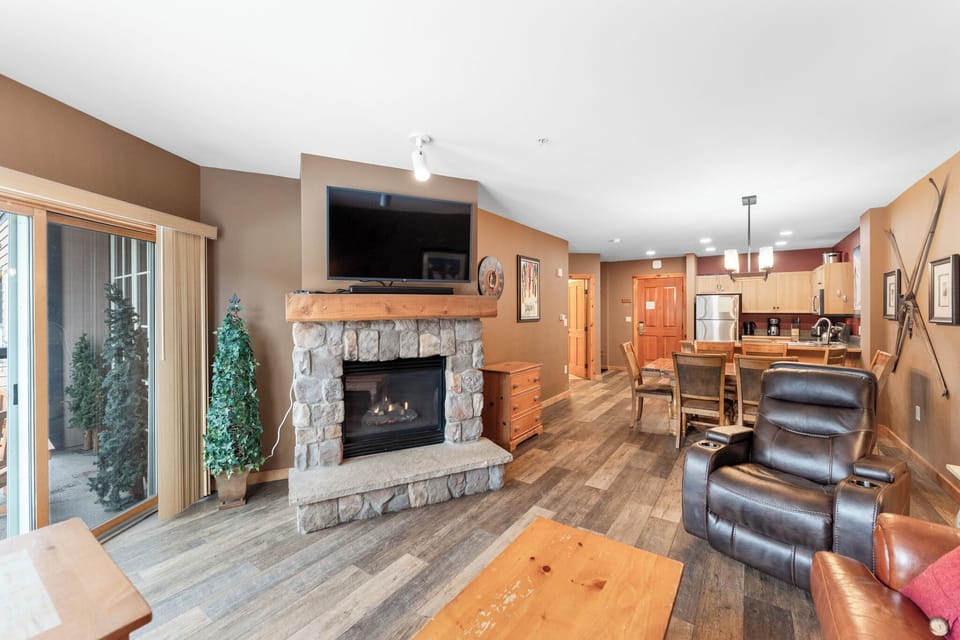 Curl up by your crackling stone fireplace while enjoying mountain views through expansive windows in this warmly appointed living space.