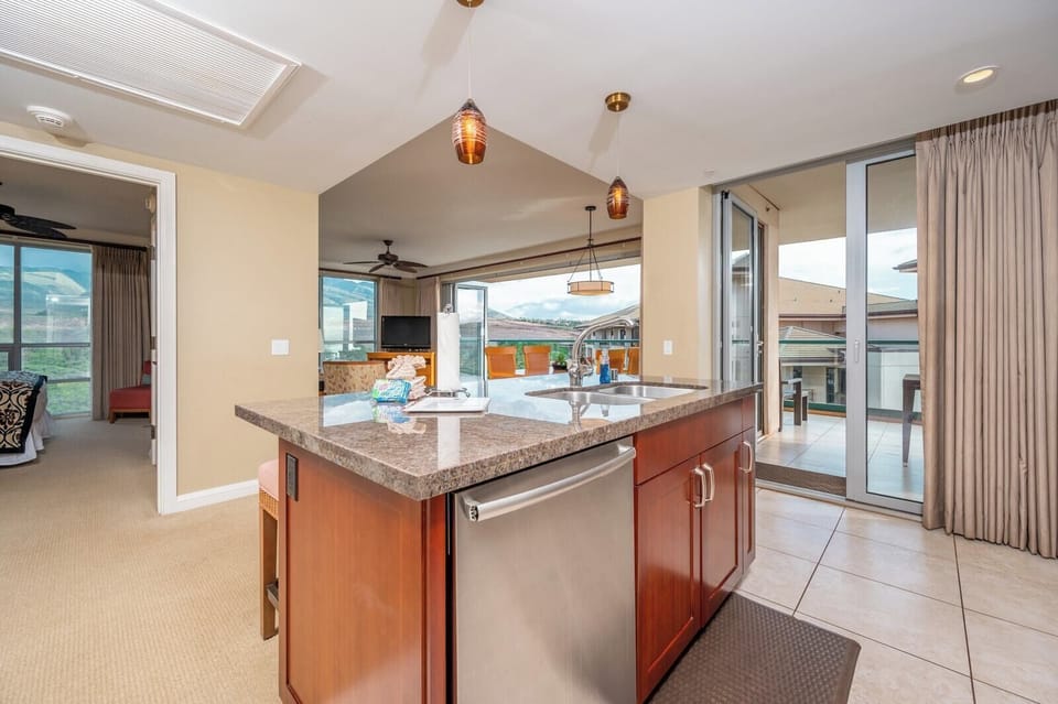Island kitchen view with mountain-side bedroom and breezy open lanai.