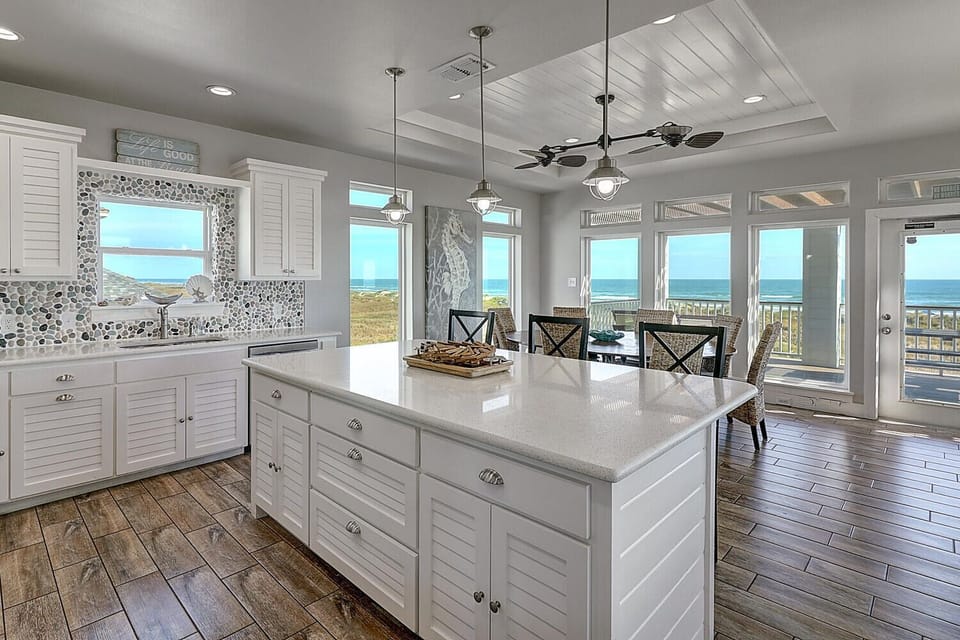 Your bright coastal kitchen offers stunning ocean views while you cook, with spacious counters perfect for preparing meals and sharing stories.