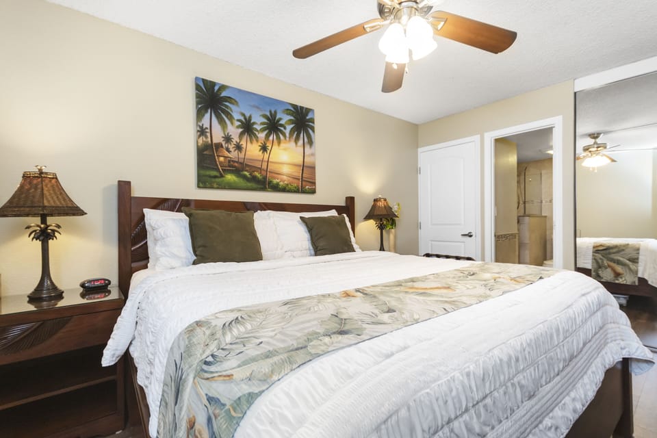 Sink into crisp linens and tropical tranquility in your serene bedroom retreat, where ceiling fans and island-inspired touches create the perfect escape.
