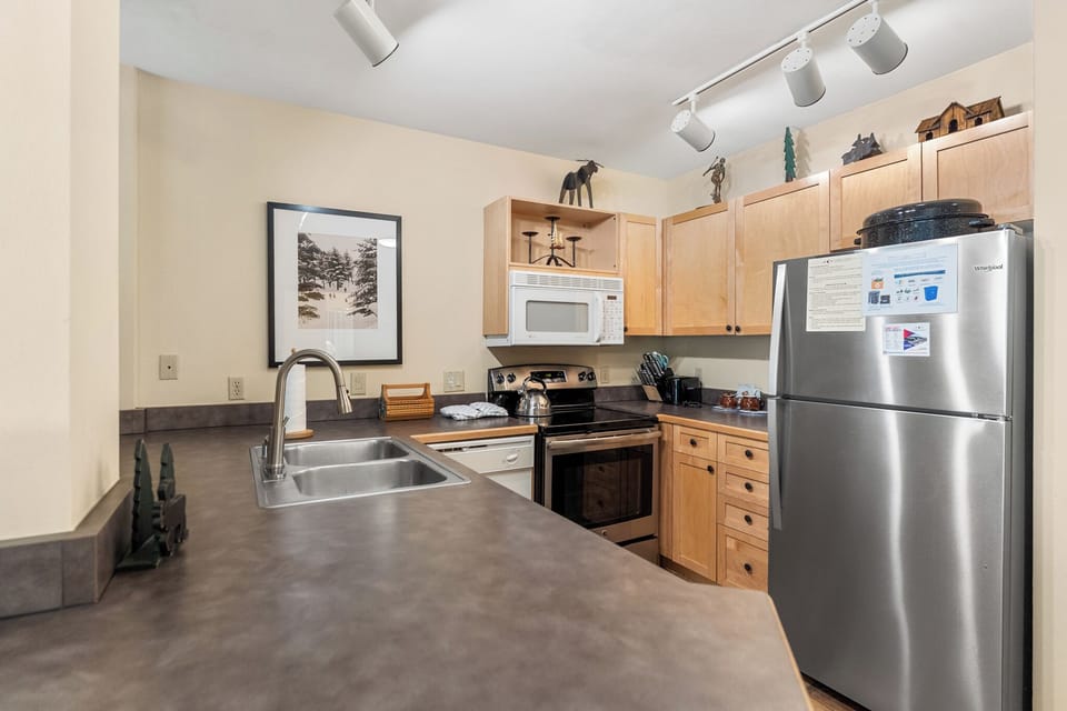 Your fully equipped kitchen features modern appliances and warm wood cabinetry, perfect for preparing meals during your mountain getaway.