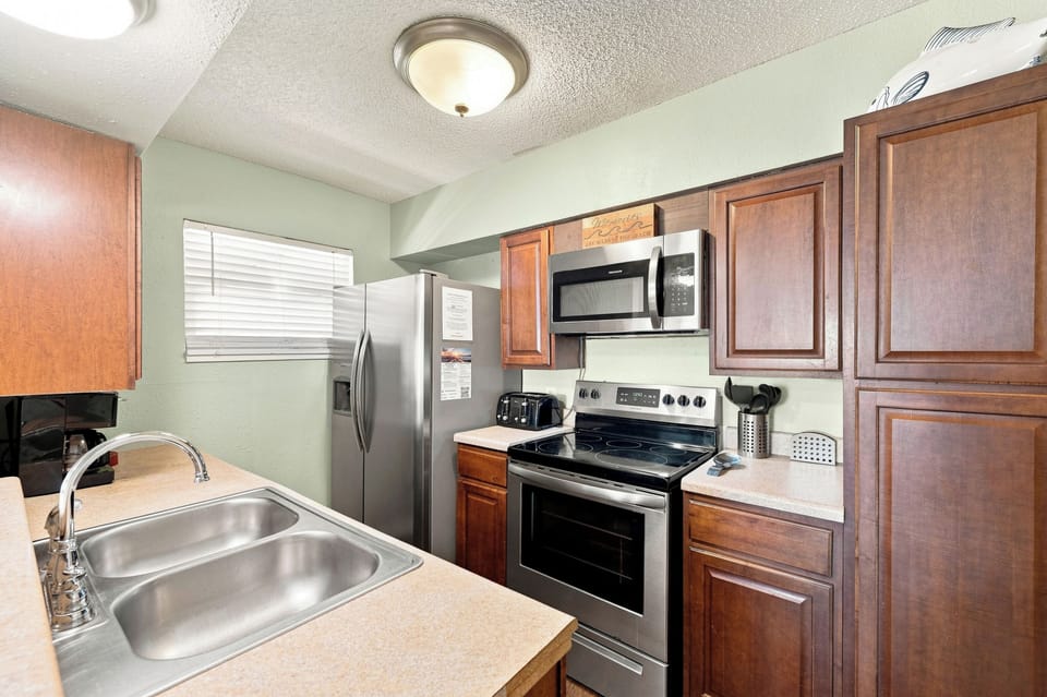Your fully equipped kitchen features stainless steel appliances, rich wood cabinetry, and plenty of counter space for preparing home-cooked meals during your stay.
