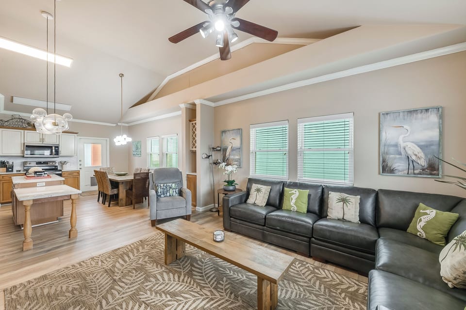 Living area looking into kitchen - Relax and unwind in this inviting living area, featuring direct access to the dining space and outdoor deck