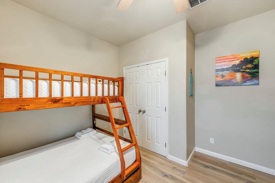 Your kids will love this cheerful bunk bed room with coastal artwork and fresh linens ready for adventure-filled nights.