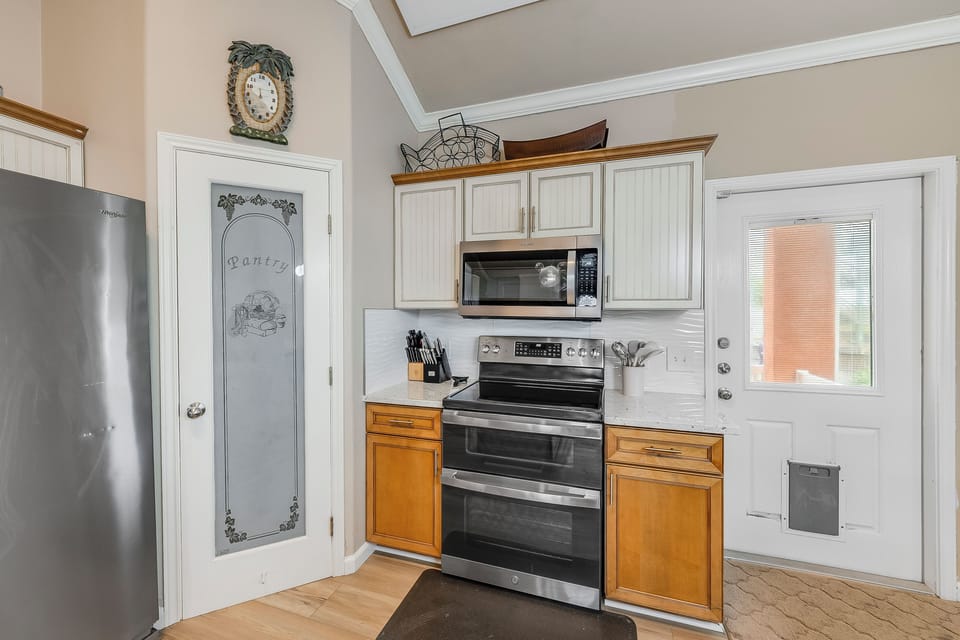 Kitchen and deck door - Designed for convenience, this cozy kitchen is perfect for whipping up meals on your vacation.