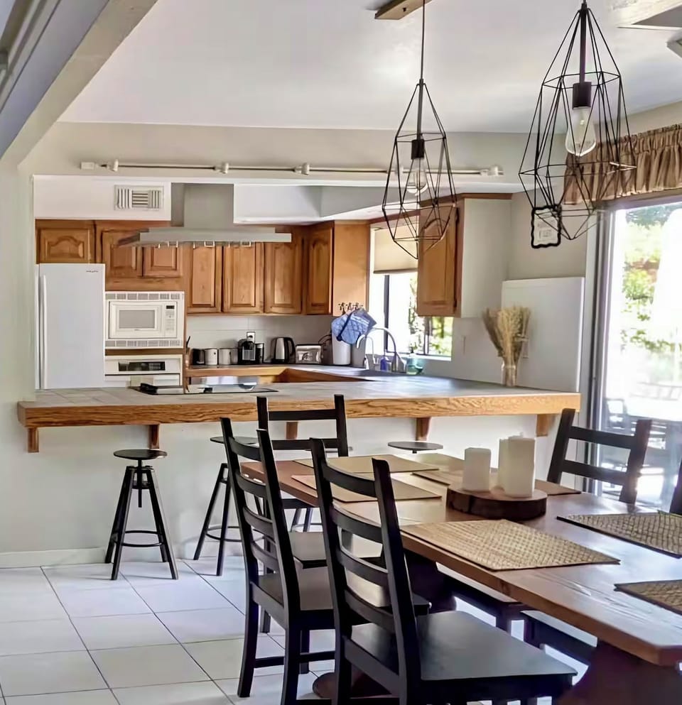 The bright open kitchen has bar seating for 4 and a farm table ready for 6+