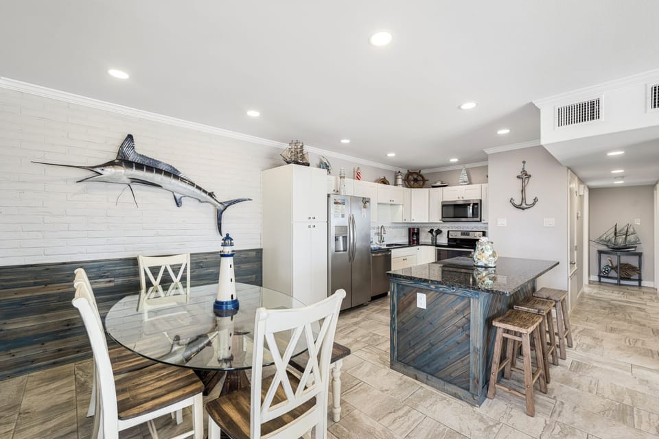 Your coastal-inspired open kitchen and dining area blends nautical charm with modern convenience for memorable meal prep.