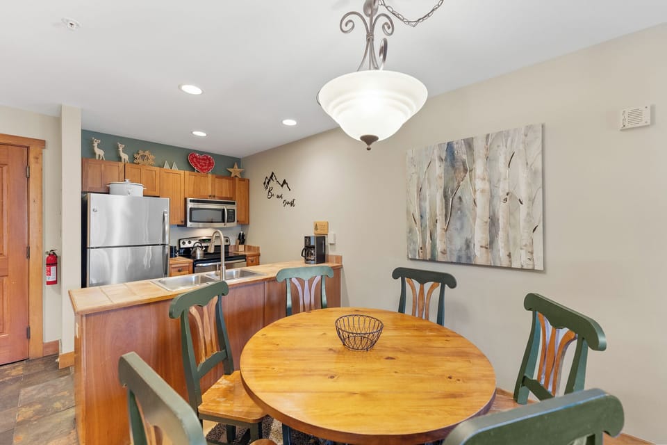 Gather around your cozy dining table for morning coffee and evening meals in this open-concept space with beautiful mountain-themed décor.