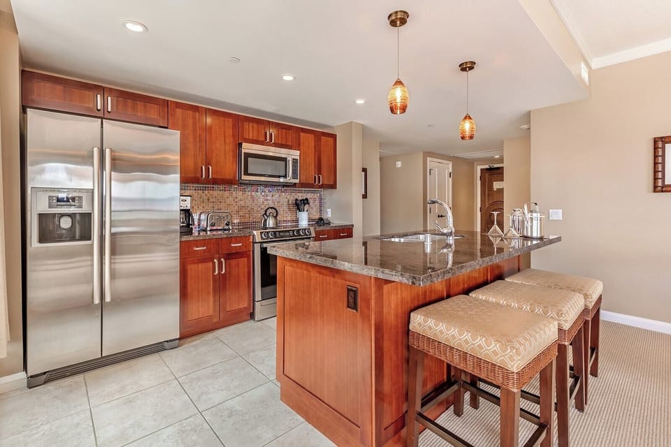 Stylish kitchen with island seating, granite counters, and pendant lighting.