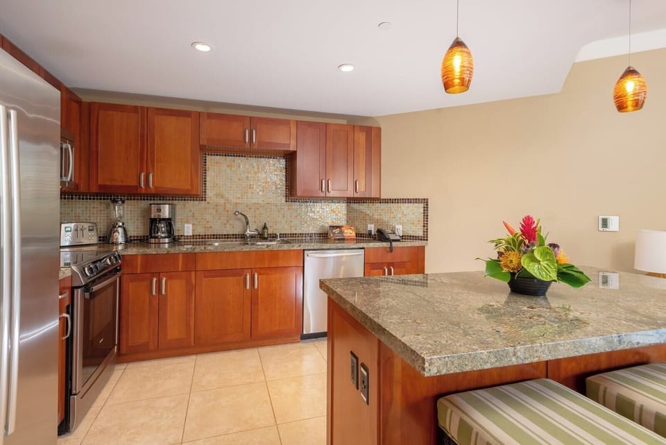 Spacious kitchen with rich cabinetry, full appliance suite, and cozy lighting for casual or gourmet meals