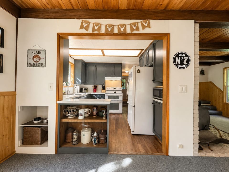 Your fully equipped kitchen awaits with modern appliances, ample counter space, and charming rustic touches throughout. Cook memorable meals under warm wood-paneled ceilings in this welcoming mountain retreat.