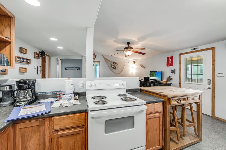 Your well-equipped kitchen invites you to prepare meals with modern appliances, warm wood cabinets, and a cozy breakfast island for casual dining.