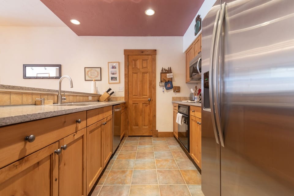 Your spacious kitchen features warm wood cabinetry, granite countertops, and stainless steel appliances for comfortable meal preparation.
