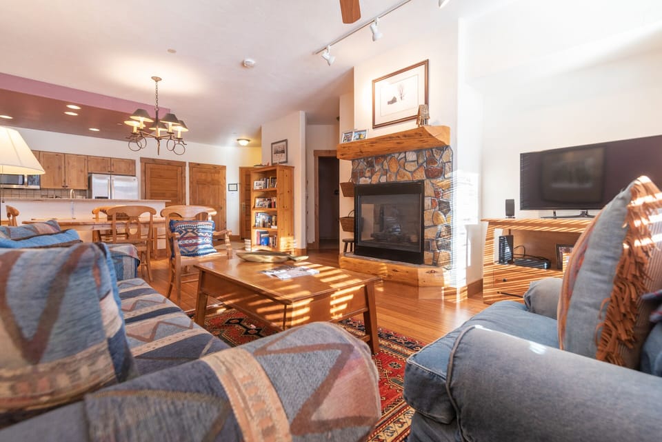 Relax in your spacious living room with cozy fireplace, hardwood floors, and open-concept design connecting to the fully equipped kitchen.