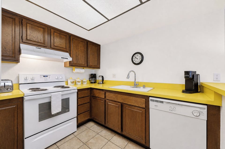 Your cheerful kitchen awaits with bright yellow countertops, wood cabinetry, and full-size appliances. Brew your morning coffee and whip up memorable meals in this inviting space.