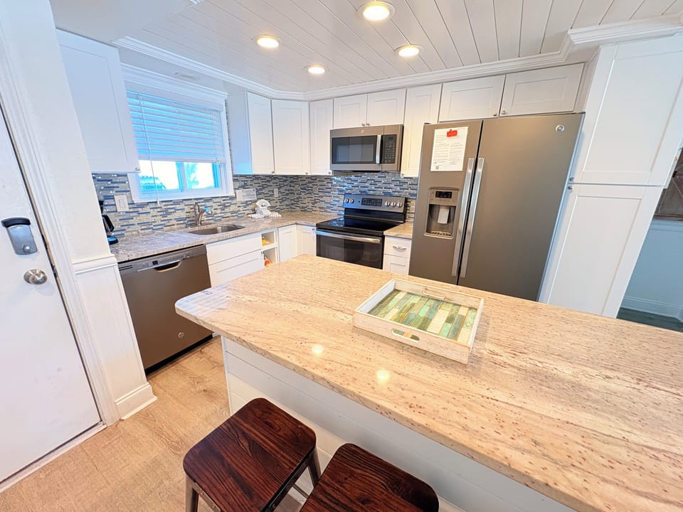 Your fully equipped kitchen features granite countertops, stainless appliances, and a breakfast bar perfect for morning coffee.