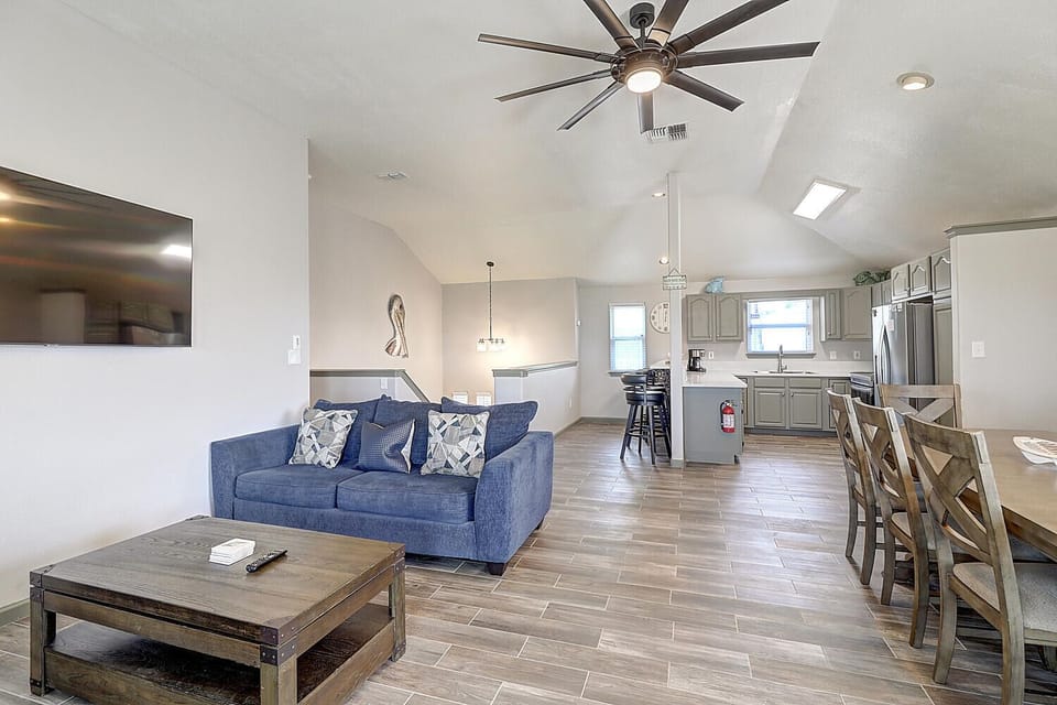 Relax in this open-concept living space where the blue sofa invites you to unwind while the full kitchen awaits your culinary adventures.