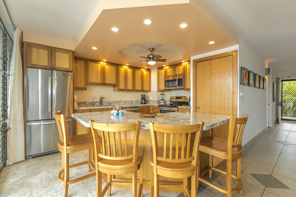 Gather around the spacious granite island where morning coffee and evening meals come alive. You'll love the warm wood cabinetry, stainless appliances, and abundant counter space for preparing your favorite dishes.