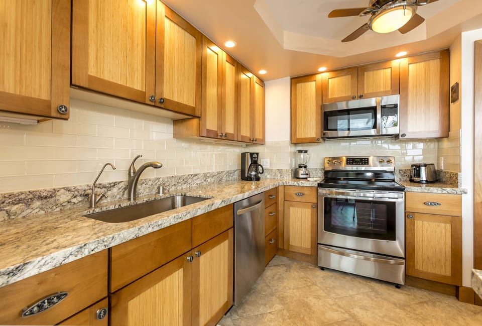 Your fully equipped kitchen features granite countertops, stainless steel appliances, and warm wood cabinetry—everything you need to prepare your favorite meals in comfort and style.