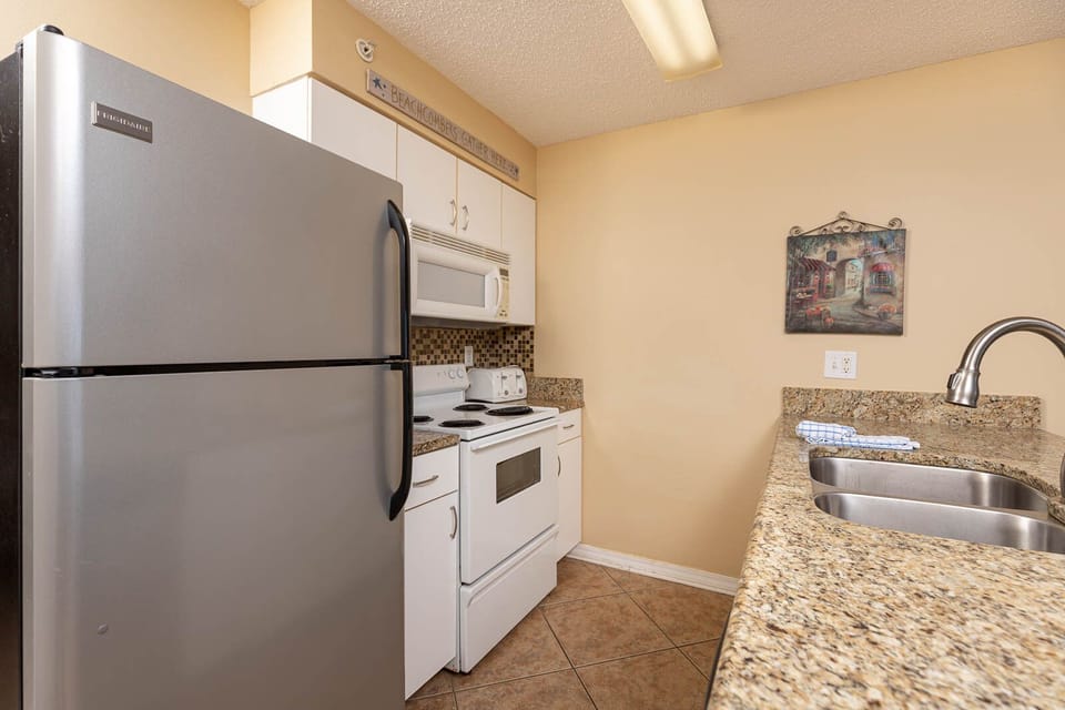 This kitchen features essential appliances, granite countertops, and a cozy atmosphere perfect for preparing meals