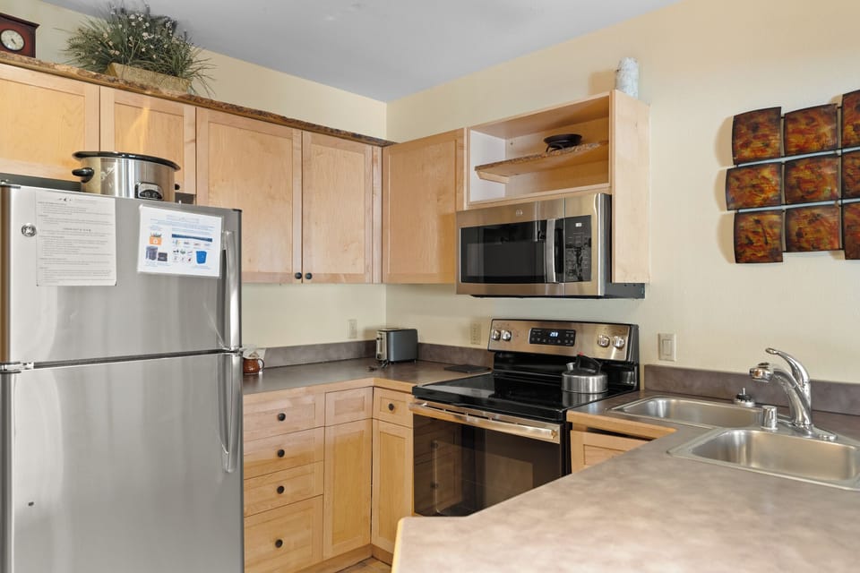 Your fully equipped kitchen awaits with stainless steel appliances, ample counter space, and warm wood cabinets for preparing memorable meals.